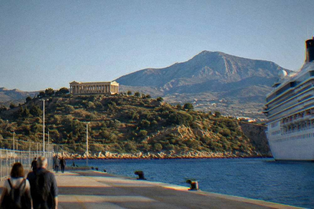 A Greek temple on a hillside in western Sicily with mountains behind it under a clear sky
