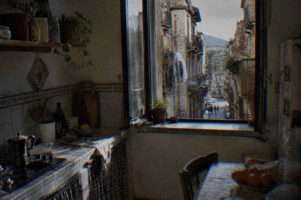 A Palermo apartment kitchen with tiled counters and a window onto a narrow street
