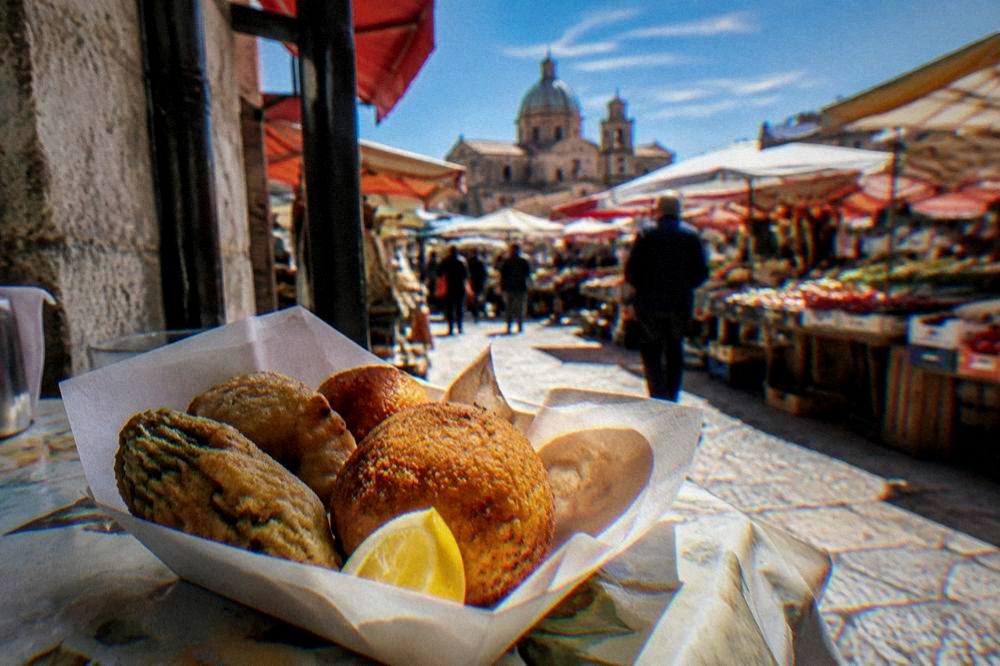 A paper tray of fried Palermo street food on a market table