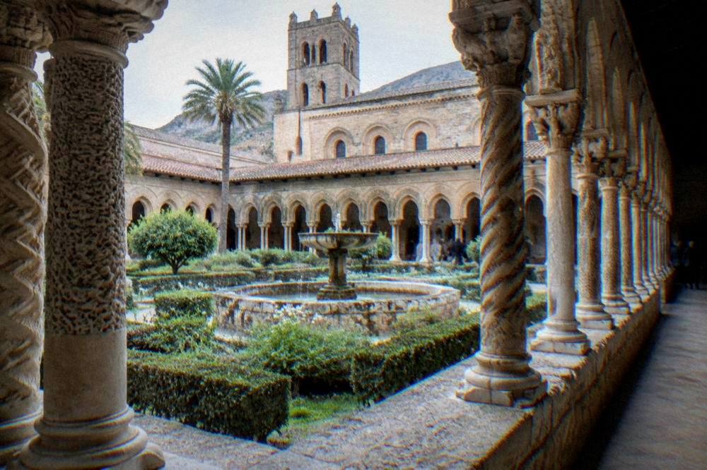 Twin rows of carved columns in the Monreale cloister with a fountain in the centre
