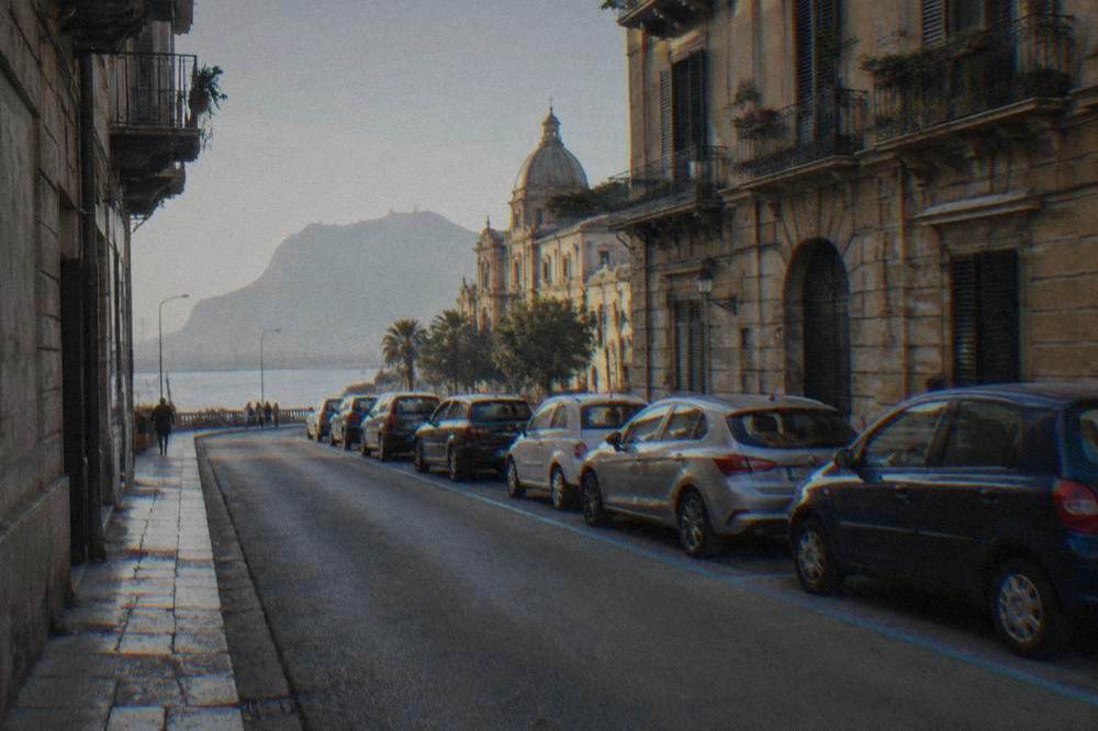 Cars parked along blue line markings on a street in Palermo