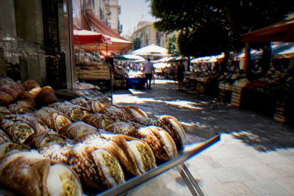 Cannoli filled with ricotta on a tray in a Palermo pastry shop