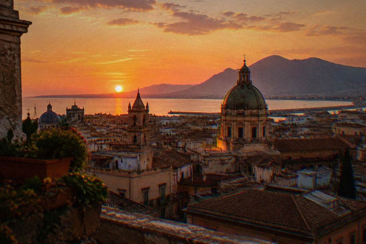 Palermo rooftops and church domes seen from above in warm evening light
