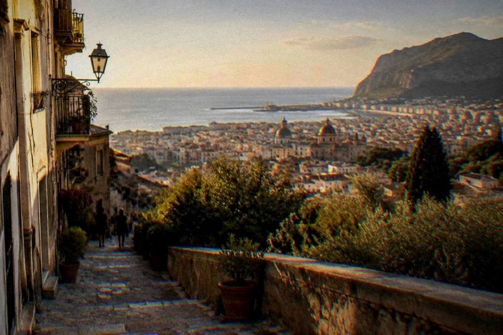 A hillside town above the coast seen across a valley in Sicily