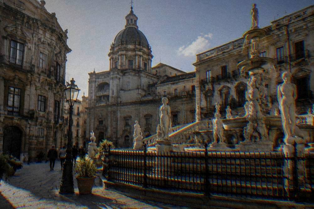 Ornate fountain and baroque facades around a city square in Palermo