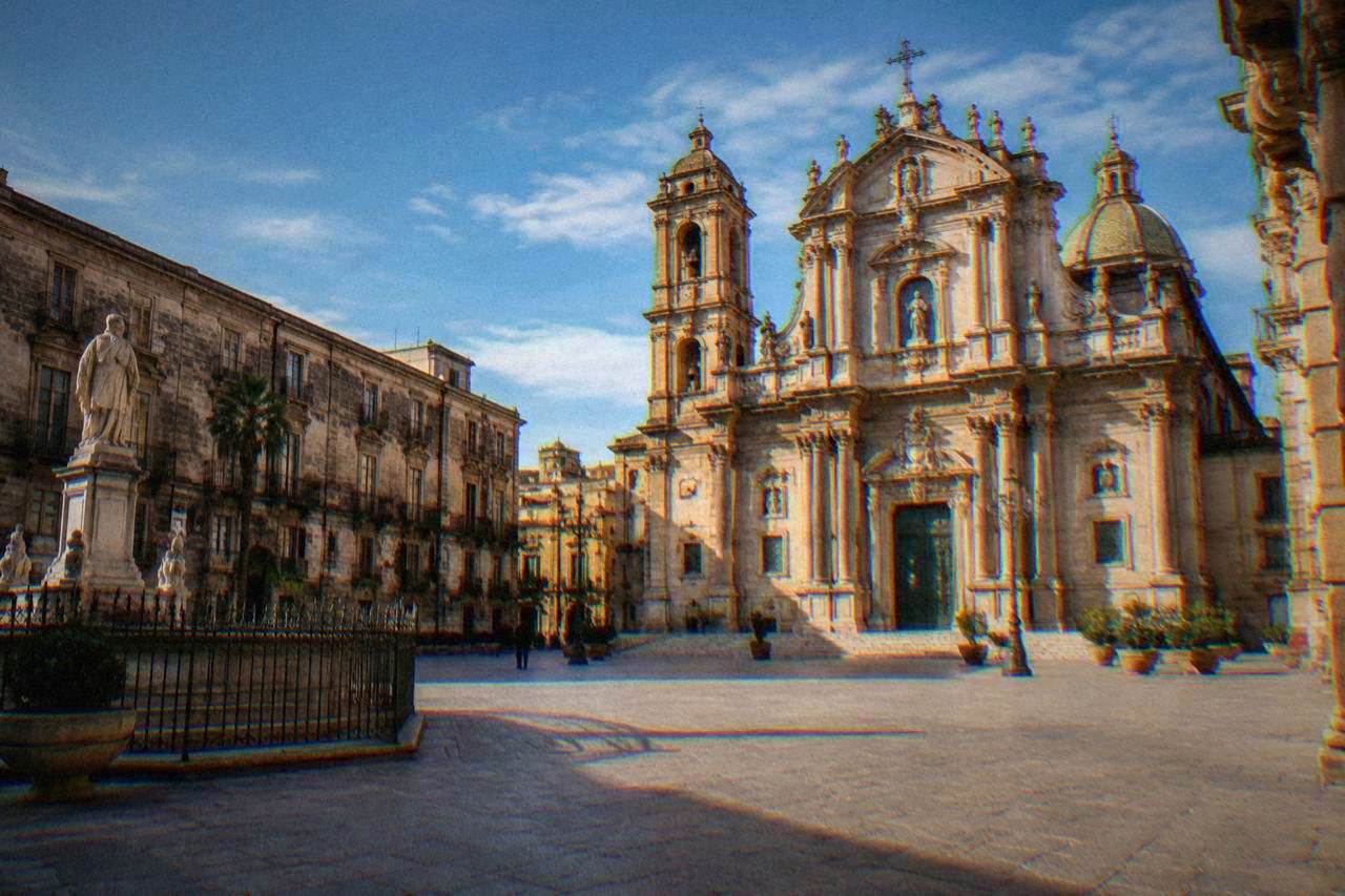 Empty historic square in Palermo under a soft winter sky with ornate church facade