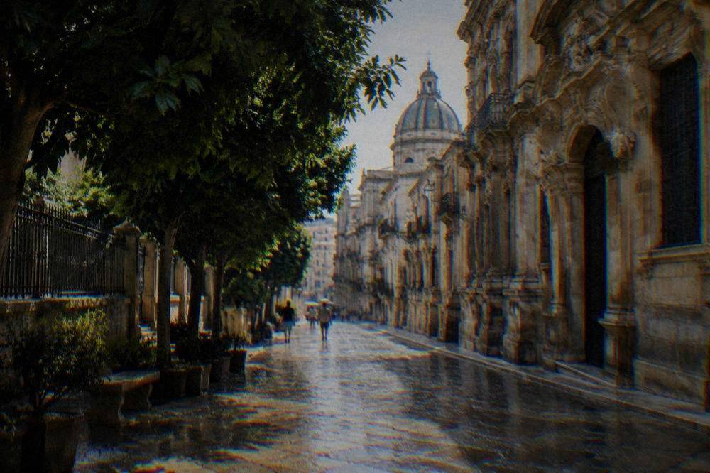 Rain-washed cobblestone street in old Palermo with baroque buildings glistening