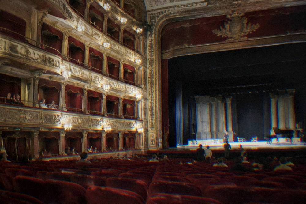 Ornate interior of Teatro Massimo with red velvet seats and gilded boxes