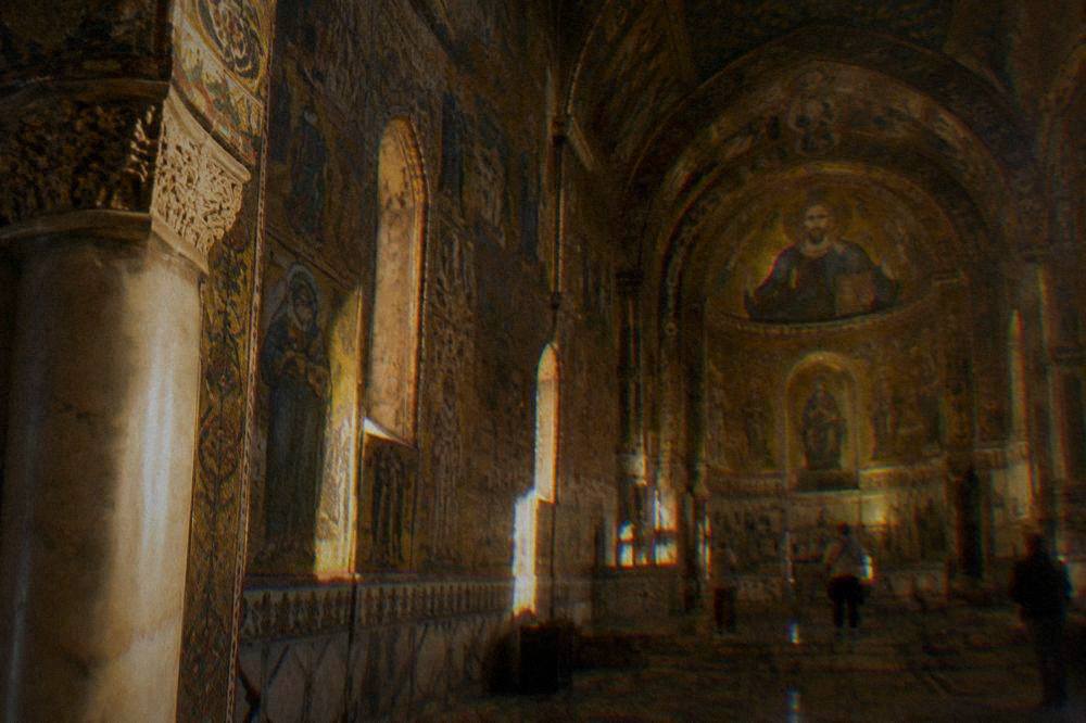 The ornate interior of a gilded chapel with mosaic decoration on walls and ceiling