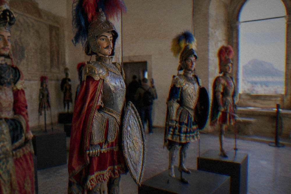 Colourful traditional Sicilian puppets displayed on stands in a puppet museum