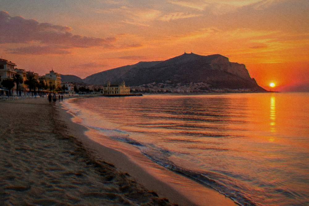Long sandy beach and seafront buildings in warm evening light