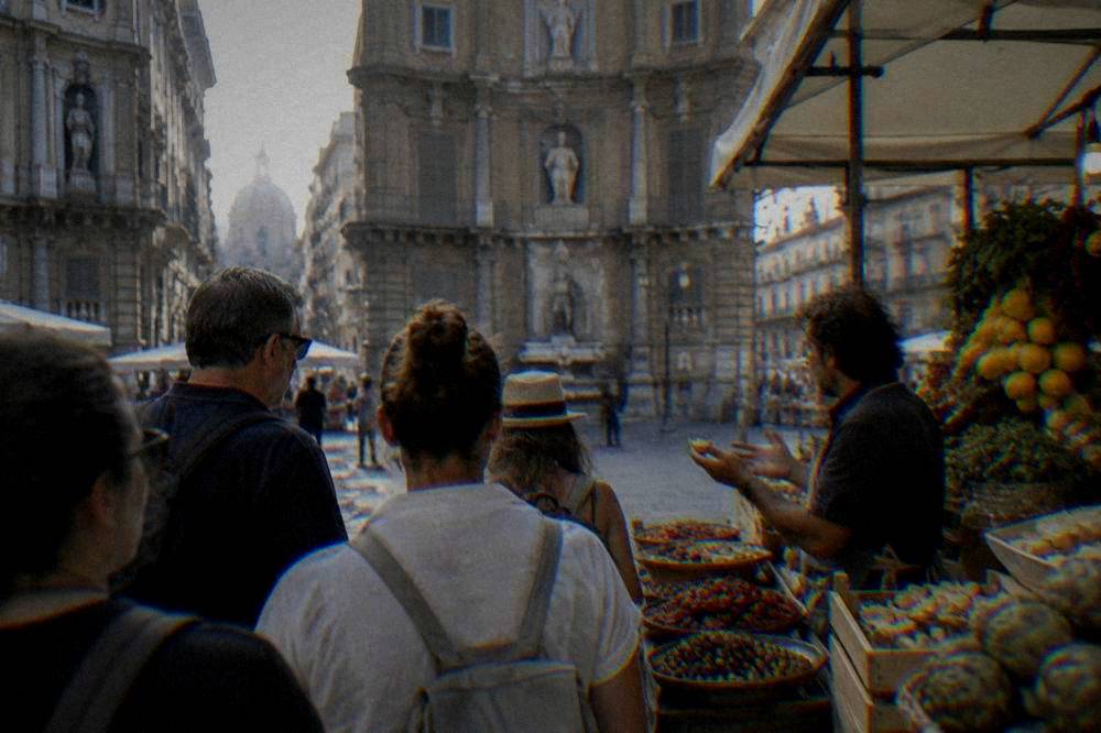 Small group following a guide through a Palermo food market with tastings at a stall