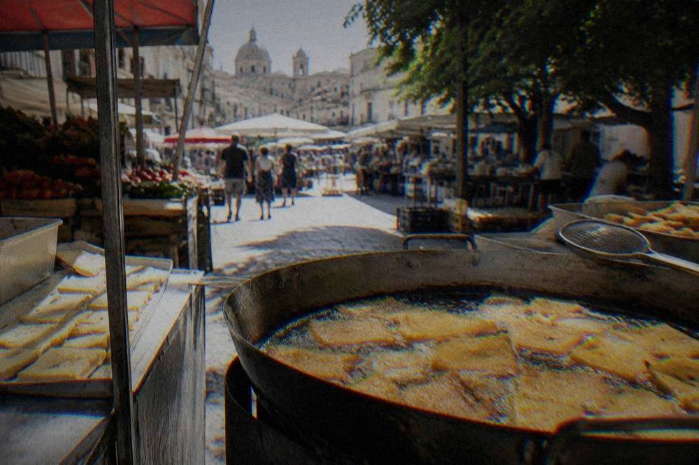 Panelle chickpea fritters frying golden in a wide pan at a Palermo market stall