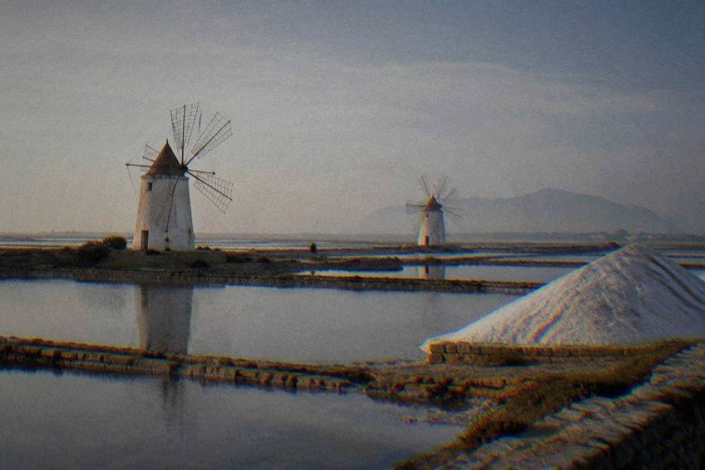 White windmills standing in the salt pans of western Sicily near Trapani