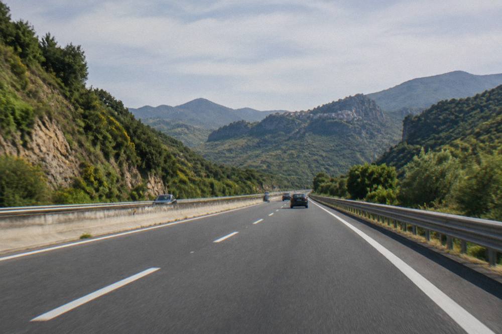 A toll-free Sicilian motorway cutting through green inland mountains