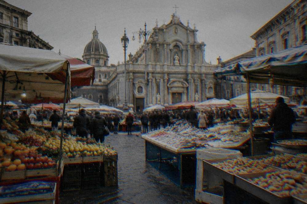 A busy Sicilian street market with stalls of fruit, fish and fried snacks