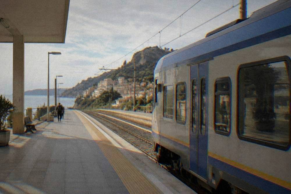 A regional train waiting at a platform in an Italian railway station