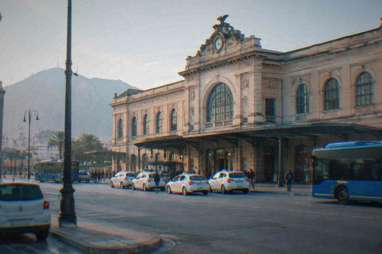 The front facade of Palermo Centrale railway station with taxis and buses outside