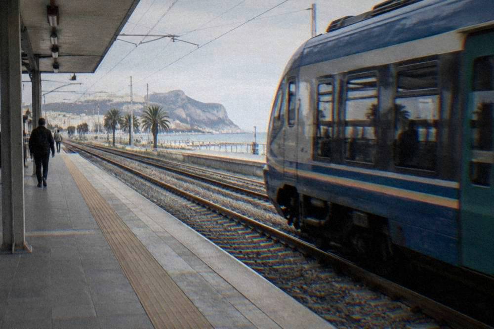 A regional train departing the platform at Palermo Centrale towards the coast