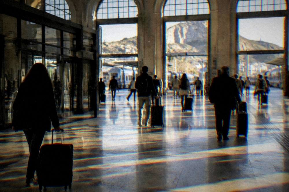 Travellers with suitcases crossing the ticket hall of Palermo Centrale station
