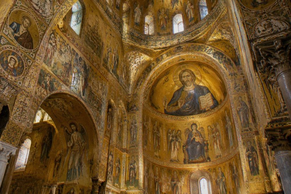 Ornate interior of a Palermo chapel with gold mosaics on every wall and dome