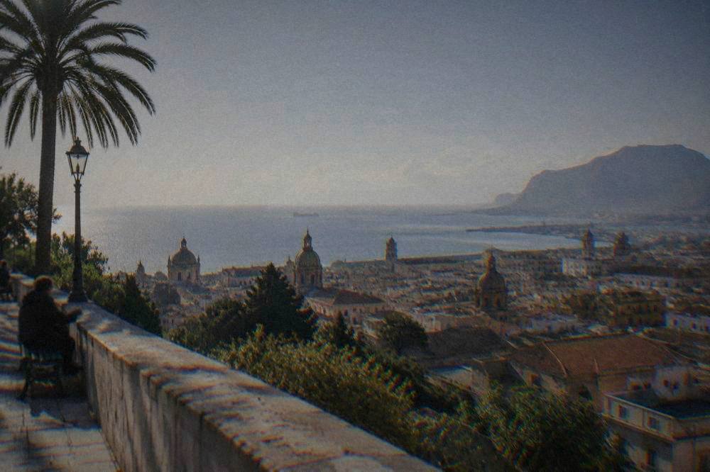 A sunny view over Palermo rooftops toward the Tyrrhenian Sea from a high terrace