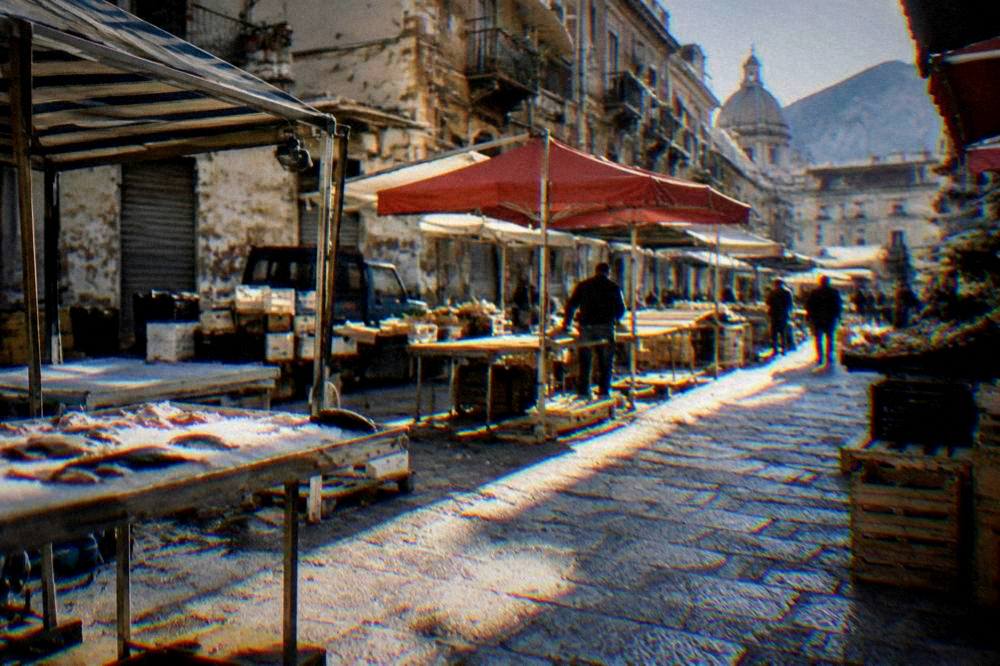 Morning light on a Palermo street with market stalls being set up