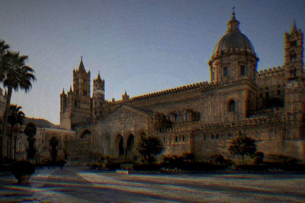 A golden-limestone cathedral with battlemented towers against a clear winter sky