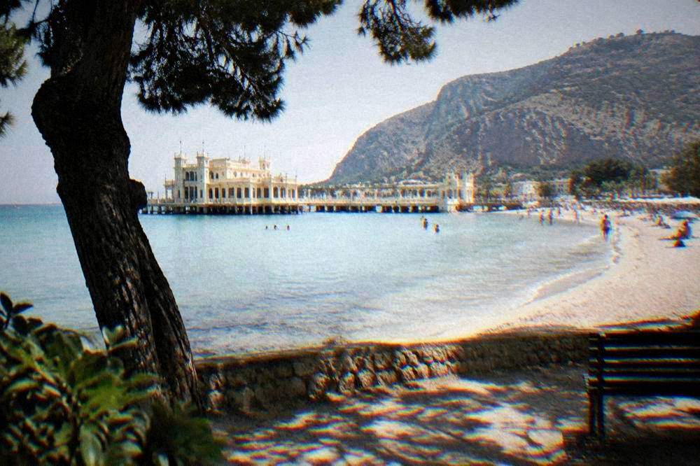 The curved sandy bay at Mondello with the Liberta style bathing establishment