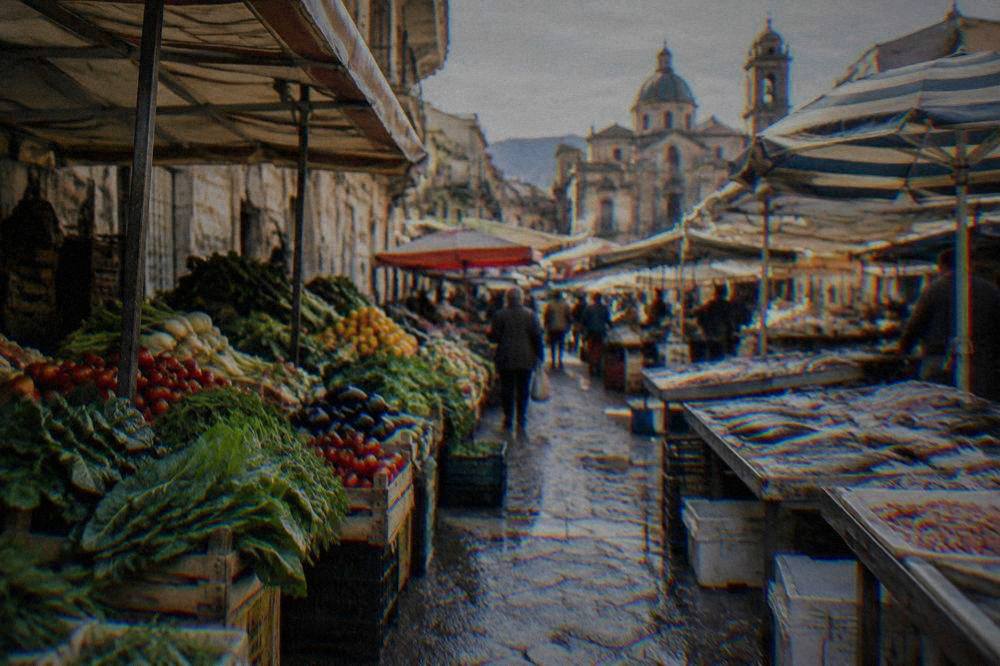 Morning stalls of a Palermo street market with crates of vegetables and fish