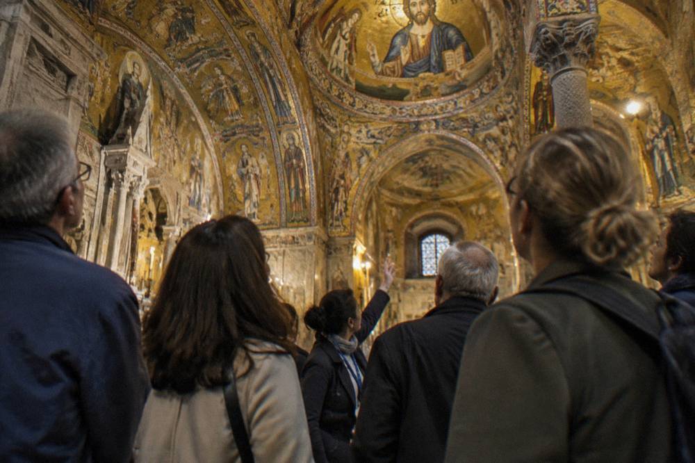 Guided group standing inside a gilded chapel with mosaic ceilings