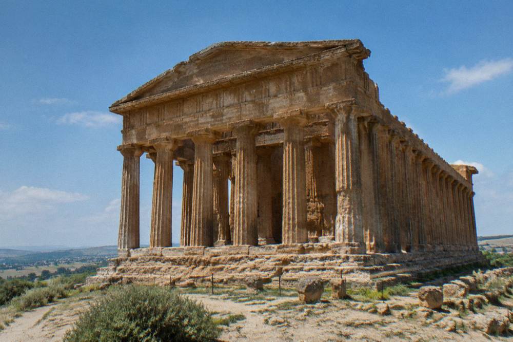 Ancient Greek temple standing on a Sicilian hillside at midday