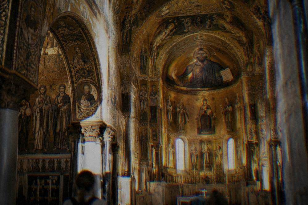 Interior of a gilded chapel with mosaic-covered walls and ceiling in Palermo