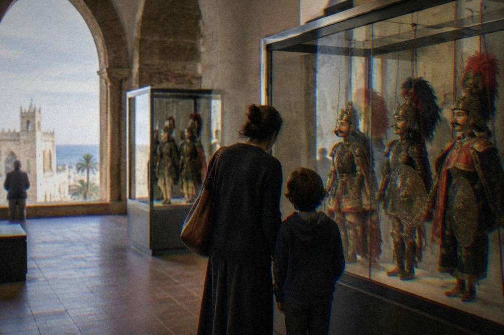 A parent and child looking at glass cases of traditional Sicilian puppets in a museum