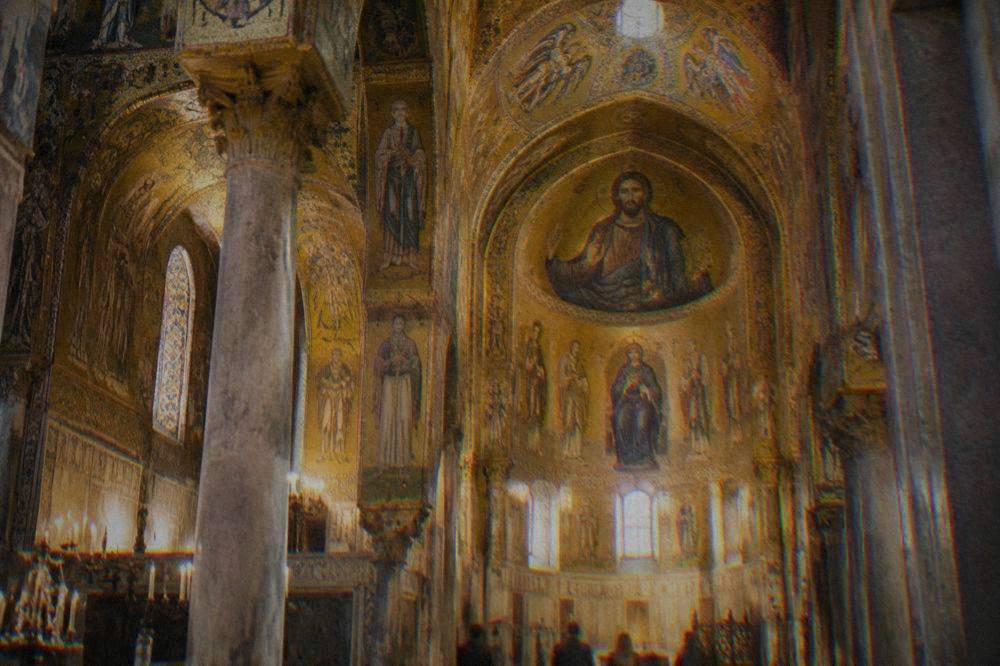 Golden mosaic interior of the Palatine Chapel in Palermo lit by warm light