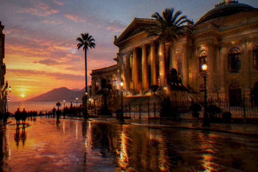 Evening lights reflecting on a wet street outside the Teatro Massimo in Palermo