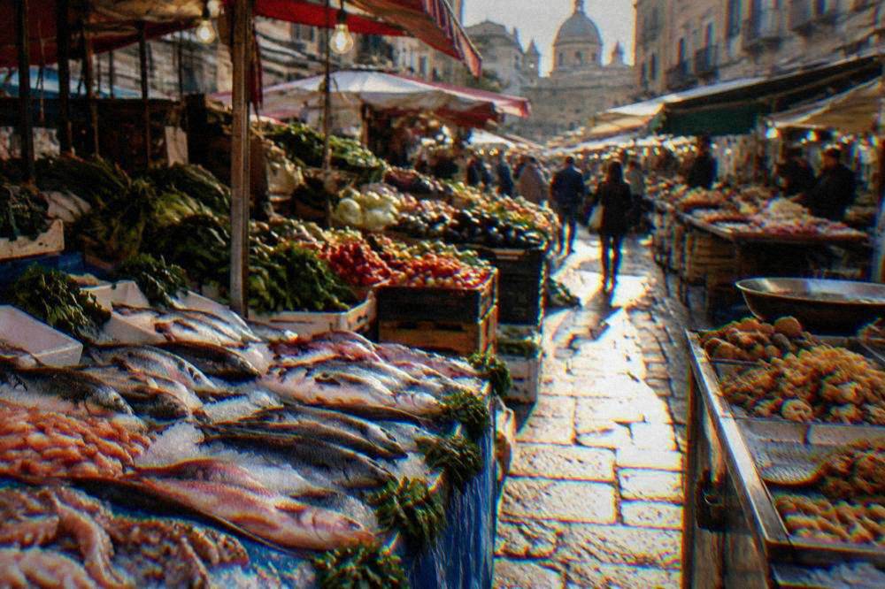 Stalls of the Ballarò market piled with vegetables, fish and fried street food
