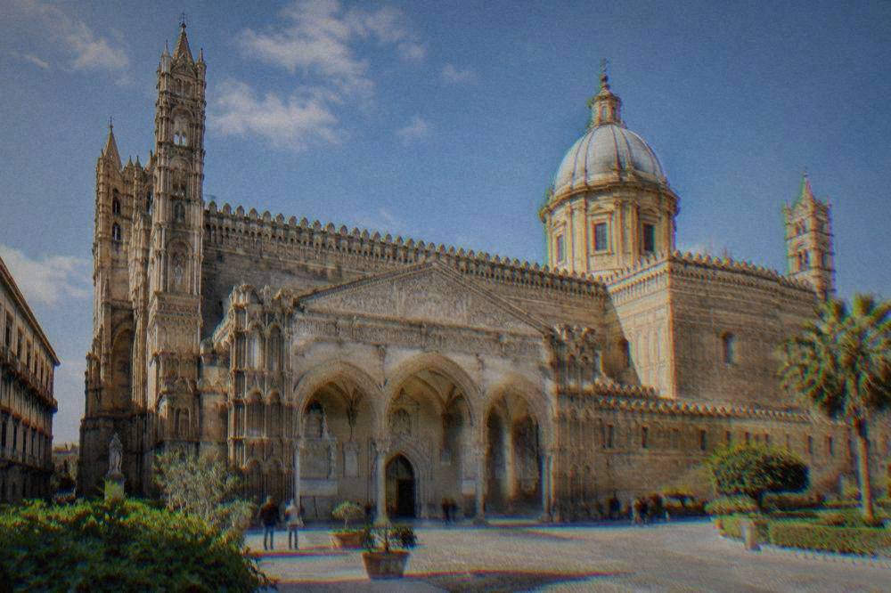 The ornate southern porch and towers of Palermo Cathedral seen from the square in bright morning light